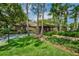 Single Gathering home featuring lush landscaping, mature trees, and a paved driveway at 3062 Eastland Blvd # 402, Clearwater, FL 33761