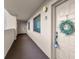 Exterior hallway leading to unit 402, which has a decorative wreath on the front door at 3062 Eastland Blvd # 402, Clearwater, FL 33761
