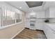 Bright kitchen featuring white cabinets, modern appliances, and laminate wood flooring at 3062 Eastland Blvd # 402, Clearwater, FL 33761