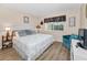 Comfortable main bedroom featuring wood floors, a decorative headboard, and a sitting chair at 3062 Eastland Blvd # 402, Clearwater, FL 33761