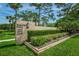 Well-maintained community sign surrounded by lush landscaping and mature trees at 3062 Eastland Blvd # 402, Clearwater, FL 33761
