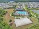 Beautiful aerial view of community pool, basketball court, clubhouse, and surrounding homes and landscape at 32803 Pez Landing Ln, Wesley Chapel, FL 33543