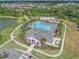 Aerial view of the community pool and clubhouse, surrounded by palm trees and green spaces at 32803 Pez Landing Ln, Wesley Chapel, FL 33543