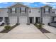 Well-maintained townhomes featuring attached garages and manicured landscaping at 32803 Pez Landing Ln, Wesley Chapel, FL 33543