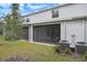 Exterior view of a home's screened patio, backyard, and surrounding green space and two AC Units at 32803 Pez Landing Ln, Wesley Chapel, FL 33543