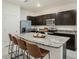 Modern kitchen featuring granite countertops, stainless steel appliances, and a center island with bar seating at 32803 Pez Landing Ln, Wesley Chapel, FL 33543