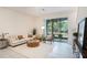 Bright and inviting living room featuring neutral paint colors, tile floors and a sliding glass door to patio at 32803 Pez Landing Ln, Wesley Chapel, FL 33543