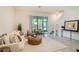 Bright and inviting living room featuring neutral paint colors, tile floors and a sliding glass door to patio at 32803 Pez Landing Ln, Wesley Chapel, FL 33543
