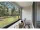 Screened patio with chairs overlooks a tranquil backyard with lush greenery and shade trees at 32803 Pez Landing Ln, Wesley Chapel, FL 33543