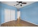 Bright bedroom with hardwood floors, a ceiling fan, and a large closet at 3434 St Ives Blvd, Spring Hill, FL 34609