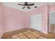 Bedroom featuring tan hardwood floors, a ceiling fan, and a large closet at 3434 St Ives Blvd, Spring Hill, FL 34609