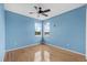 Serene bedroom with a ceiling fan, hardwood floors, and two windows offering great outdoor views at 3434 St Ives Blvd, Spring Hill, FL 34609