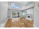 Bright living room featuring wood floors, high ceilings, fireplace, and sliding doors to the pool at 3434 St Ives Blvd, Spring Hill, FL 34609