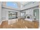 Bright living room with fireplace, hardwood floors, and view of the outdoor pool at 3434 St Ives Blvd, Spring Hill, FL 34609