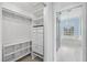 Walk-in closet and view of the bathroom featuring marble-tiled floor and soaking tub under a window at 3434 St Ives Blvd, Spring Hill, FL 34609