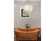 Bathroom highlighting a copper soaking tub under a contemporary light fixture, tiled walls and dark framed window at 3501 W Tacon St, Tampa, FL 33629