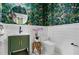 Charming powder room features green vanity, designer wall paper, and shiplap accents at 3501 W Tacon St, Tampa, FL 33629