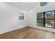 Bright bedroom featuring hardwood floors and large windows with neighborhood views at 3501 W Tacon St, Tampa, FL 33629