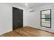 Bright bedroom featuring hardwood floors, black closet doors, and window with a view at 3501 W Tacon St, Tampa, FL 33629