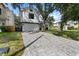 Large brick driveway leading to a modern home with a two-car garage and a manicured lawn at 3501 W Tacon St, Tampa, FL 33629