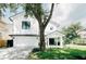 Charming two-story home featuring a manicured lawn, brick driveway, and classic black and white color scheme at 3501 W Tacon St, Tampa, FL 33629