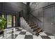 Entryway featuring modern staircase, black paneled walls, and black and white marble floors at 3501 W Tacon St, Tampa, FL 33629