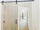 Hallway with hardwood floors and a rustic sliding barn door at 3501 W Tacon St, Tampa, FL 33629
