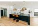 Kitchen features black island, countertops and brass pendant lights above the kitchen island at 3501 W Tacon St, Tampa, FL 33629