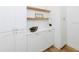 Bright butler's pantry offers white cabinets, floating shelves, and wooden floors at 3501 W Tacon St, Tampa, FL 33629