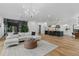 Open-concept living space featuring hardwood floors, a statement chandelier, and an open layout at 3501 W Tacon St, Tampa, FL 33629