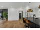 Open-concept room with hardwood flooring and modern black island with leather bar seating at 3501 W Tacon St, Tampa, FL 33629