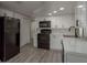 Bright kitchen with white cabinets, modern appliances, and gray wood-look flooring at 3601 Grayton Dr, New Port Richey, FL 34652