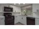 Updated kitchen with white cabinets, black appliances, stainless steel sink and grey countertops at 3601 Grayton Dr, New Port Richey, FL 34652