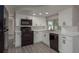Bright kitchen featuring white cabinets, modern black appliances, and granite countertops at 3601 Grayton Dr, New Port Richey, FL 34652