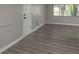 Living room featuring new gray wood-look flooring, wainscotting, and lots of natural light at 3601 Grayton Dr, New Port Richey, FL 34652