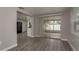 Open-concept living area with sliding glass doors to the lanai and new flooring at 3601 Grayton Dr, New Port Richey, FL 34652