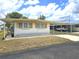 This single-story house has covered parking, mature landscaping, and a well-maintained yard at 37135 Sandra Ave, Zephyrhills, FL 33542