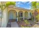 Inviting front entrance with arched entryway and tiled porch, surrounded by lush tropical foliage at 396 Avenida Madera, Sarasota, FL 34242