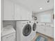 Clean laundry room with white cabinets, modern washer and dryer, and a countertop at 4175 20Th N St, St Petersburg, FL 33741