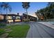 Expansive backyard with modern architectural elements, a pool, and a lush green lawn at 4610 Cypress S Way, St Petersburg, FL 33705