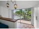 A view through sliding glass doors to a backyard featuring lush landscaping, a seating area, and unique tiled flooring at 4610 Cypress S Way, St Petersburg, FL 33705