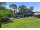 Beautifully landscaped front exterior of a modern gray home featuring a lush green lawn at 4610 Cypress S Way, St Petersburg, FL 33705