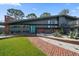 Attractive, landscaped front exterior with brick walkway, xeriscaping, and modern gray facade at 4610 Cypress S Way, St Petersburg, FL 33705