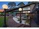 Charming mid-century home with sleek gray exterior, stylish lighting, brick walkway, and lovely landscaping at 4610 Cypress S Way, St Petersburg, FL 33705