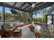 A sunroom features tropical decor, a seating area, and views of the pool and beautifully landscaped backyard at 4610 Cypress S Way, St Petersburg, FL 33705