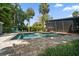 Backyard pool surrounded by palm trees and lush tropical landscaping at 4610 Cypress S Way, St Petersburg, FL 33705