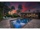 Inviting pool area with blue water, surrounded by a brick patio, lounge chairs, and tropical landscaping at 4610 Cypress S Way, St Petersburg, FL 33705