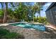 Backyard with a refreshing swimming pool surrounded by lush landscaping and a hammock at 4610 Cypress S Way, St Petersburg, FL 33705