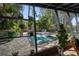 Screened-in view of backyard pool with brick pavers and lush tropical landscaping at 4610 Cypress S Way, St Petersburg, FL 33705
