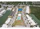 Aerial view of waterfront condos, a marina, a pool, and tennis courts in a sunny community at 467 Boca Ciega Point S Blvd, St Petersburg, FL 33708